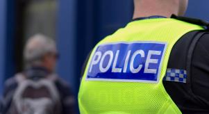 The back of a police officer wearing a reflective vest
