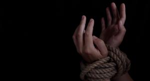 Stock image of a woman's wrists tied with rope