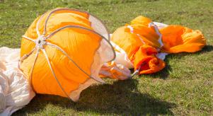 A discarded skydiving parachute on the floor in a field