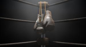 A pair of old boxing gloves hanging on the side of a boxing ring