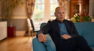 Rob Rinder sitting on a sofa