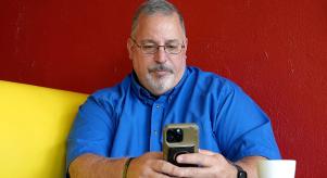 Tony Godwin using a smartphone