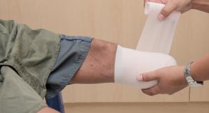 A man bandaging an empty leg