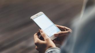 A woman typing a message on her smartphone