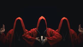 Mystery people in a red hooded cloaks in the dark. Hiding face in shadow. Pointing up with fingers. Satanic symbols. Ghostly figure.