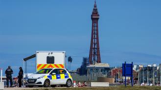 A police car parked by the beach in front of Blackpool Tower