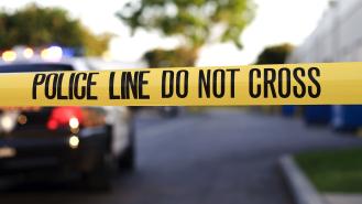 Crime scene tape and a parked police car