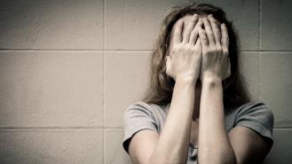 A woman holds her face in her hands