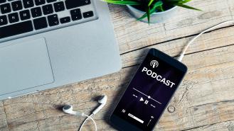 A phone playing a podcast on a desk
