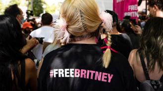 A woman wearing a t-shirt with #FREEBRITNEY written on the back