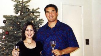 Scott and Laci Peterson hold glasses of champagne in front of a Christmas tree