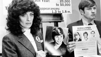 Noreen and John Gosch hold up photos of their missing son, Johnny