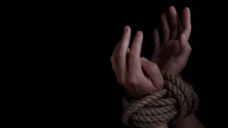 Stock image of a woman's wrists tied with rope