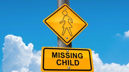 A yellow road sign with the words 'Missing Child'