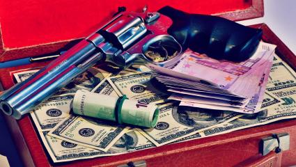 A leather suitacse full of dollars and a smith and western revolver