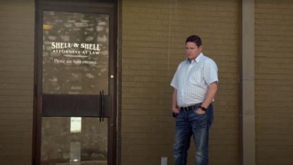 Jason McCombs standing outside 'Shell & Shell: Attorneys at Law'