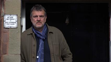 Mark Billingham leaning on a door frame