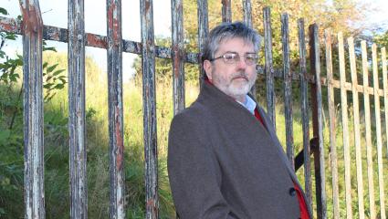 Douglas Skelton leaning against a fence