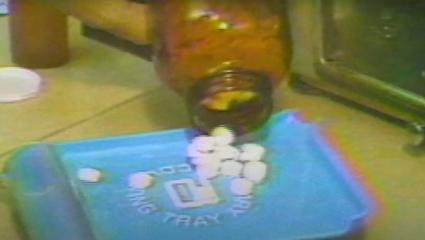 A large bottle of pills being emptied on a tray