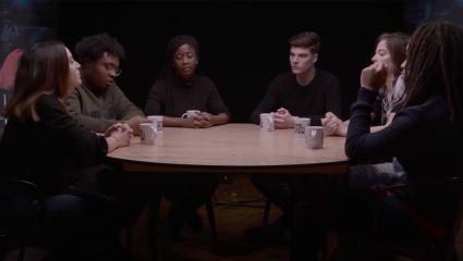Six young adults talking around a table