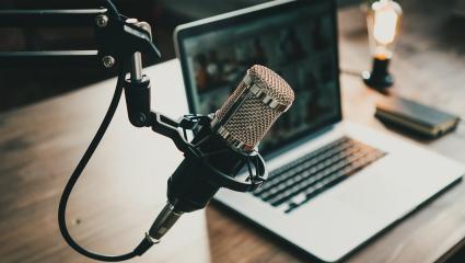 Podcast microphone next to a laptop