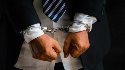 Close up of a man's wrists in handcuffs