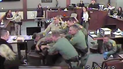 CCTV footage of numerous police officers detaining a convict inside a courtroom