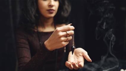 Modern fortune teller holding a dark jewel
