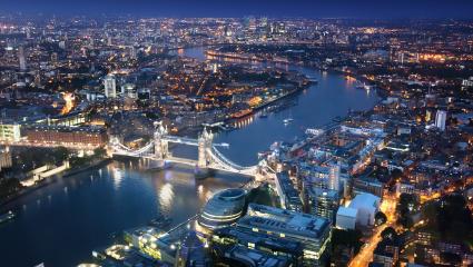 Ariel shot of the London skyline at night with Tower Bridge in the foreground