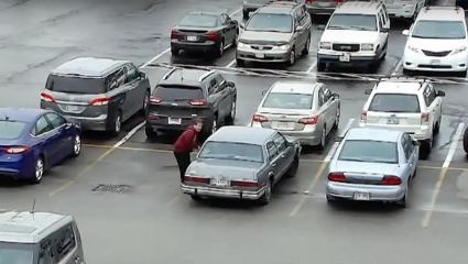 cctv footage of a busy parking lot showing a man getting into a car