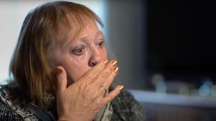 Julie, Mark Jewitt's mum, wipes her face with her hand as she cries