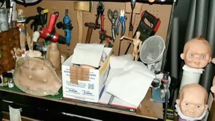 A demonic work station with lots of tools, an axe, and doll heads