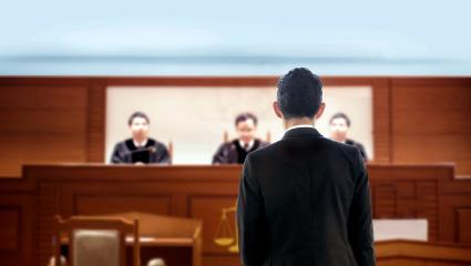 A defendant stands before a judge in a court room