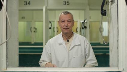 A prisoner sitting on the other side of the glass