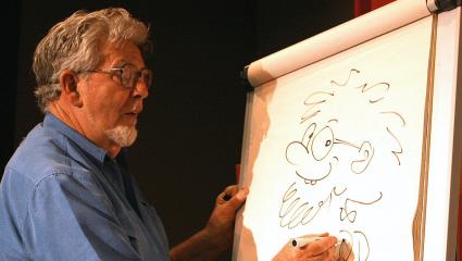 Rolf Harris draws a self portrait cartoon