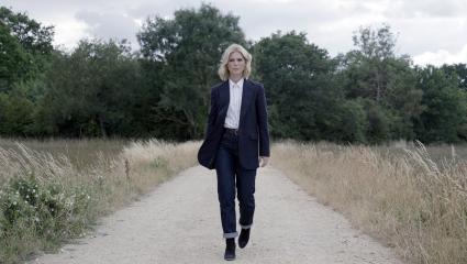 Emilia Fox walking along a dusty footpath in Peterborough