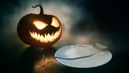 A stock photo of a pumpkin, three bullet cases and a broken plate