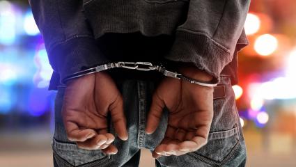 A photograph of a man in handcuffs