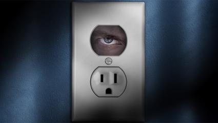 An eye looking through a plug socket