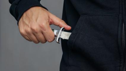 A man pulling a knife out of his pocket