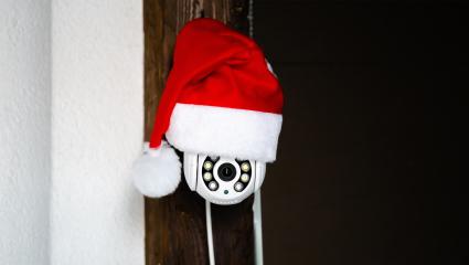 A home security camera wearing a Santa hat