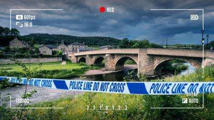 A CGI graphic showing police tape in front of a road bridge at Rothbury, Northumberland