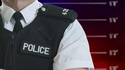 A graphic of a Police Officer in front of a Police height chart