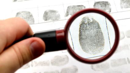 A small magnifying glass held over a fingerprint