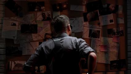A detective looking at an evidence board