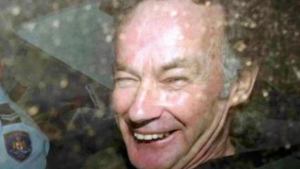 Ivan Milat laughing in the back of a police car