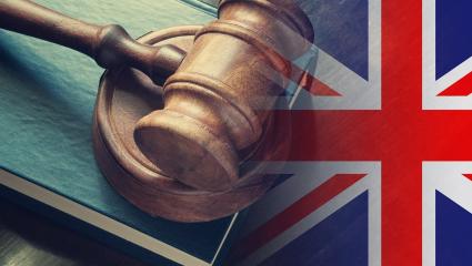 Judges wooden gavel with a United KIngdom flag in the background.