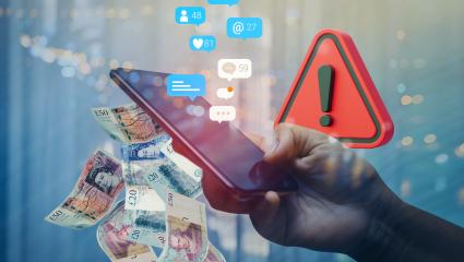 A person holding a mobile phone with a warning triangle, social media likes and UK banknotes