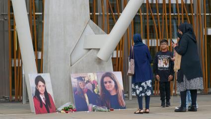 People participate in a vigil at the Scottish Parliament for Fawziyah Javed