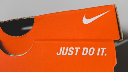 An orange Nike shoe box displaying the Nike tick and slogan, 'JUST DO IT.'